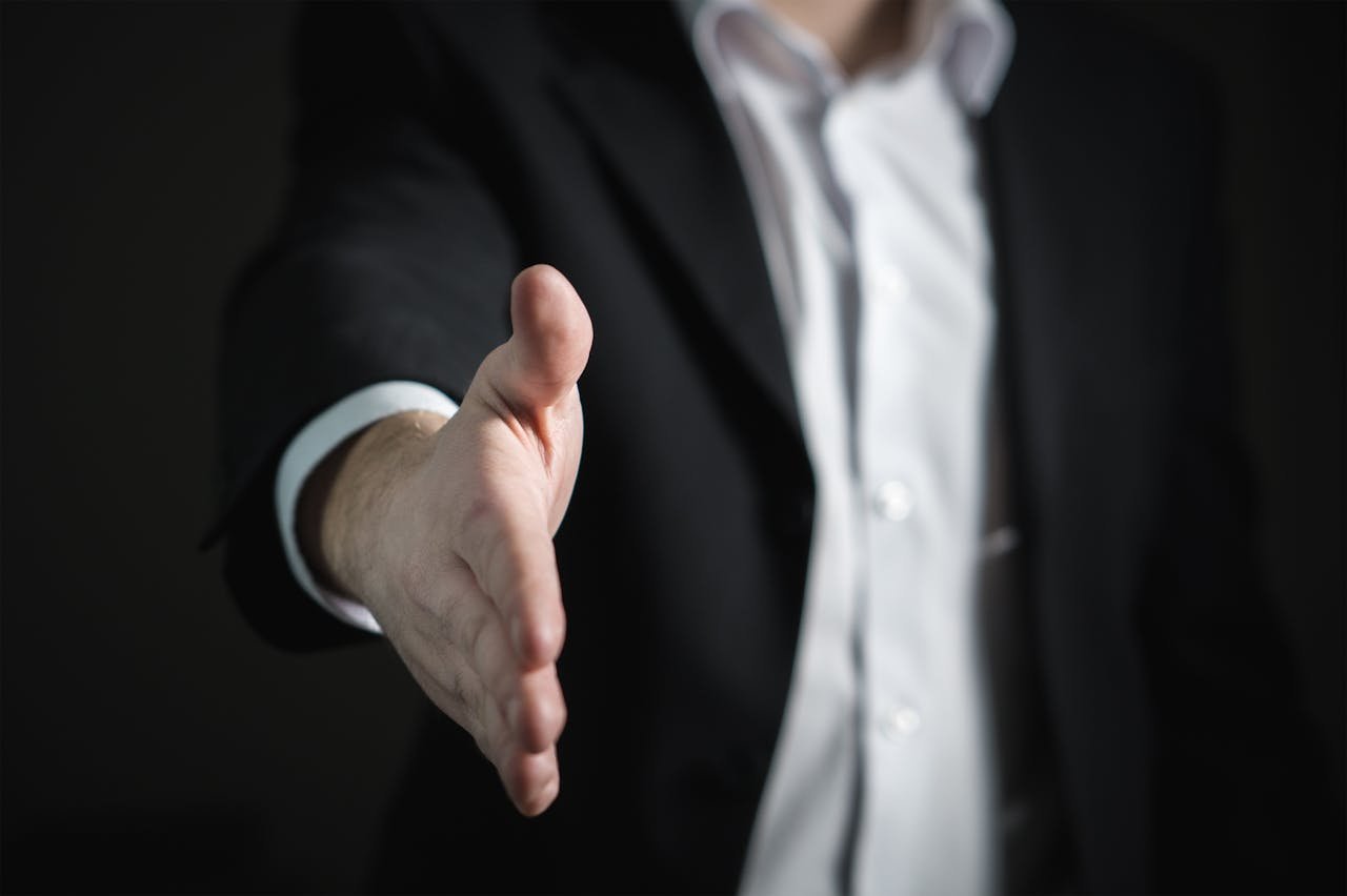 Services Close-up of a businessman extending hand for a handshake, symbolizing agreement and partnership.